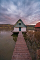 Fototapeta na wymiar Sunrise frames at the lake houses on the alpsee lake in the bavaria region of germany