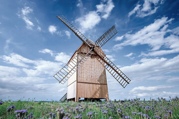 Old, traditional wooden windmill in summer scenery.