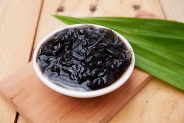 selective focus on grated black grass jelly on a white bowl. soft focus