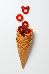 Jelly candies in waffles cones on white background, top view