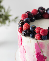 Delicious cake with cream and fresh berries on the cake pan. Birthday cake, a wedding. 