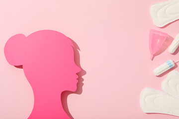 Pink female silhouette in profile with menstrual hygiene products