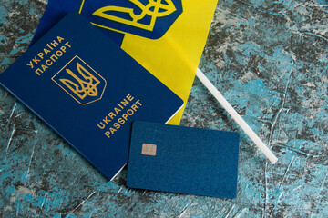 Flatlay on a dark background, Ukrainian passport, flag and bank card
