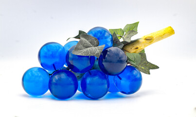 Retro old school vintage 1960s 1970s glass lucite grapes - blue and clear with green fabric leaves and driftwood stem - collectible decoration isolated on white background