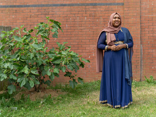 Obraz na płótnie Canvas Woman wearing hijab standing in backyard