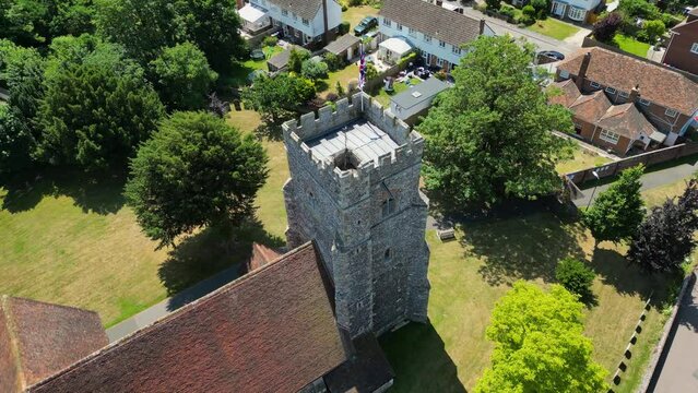 An angled arc-shot of St Mary's church in Chartham, focusing on the union flag flying from the church tower.