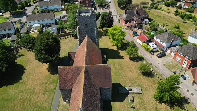 An angled push-in shot of St Mary's church in Chartham, pushing in towards the tower flying the union flag.