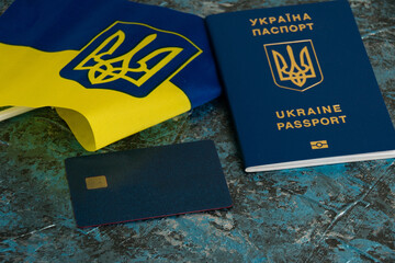 Modern bank card with chip close-up, flag of Ukraine and Ukrainian passport. The concept of...