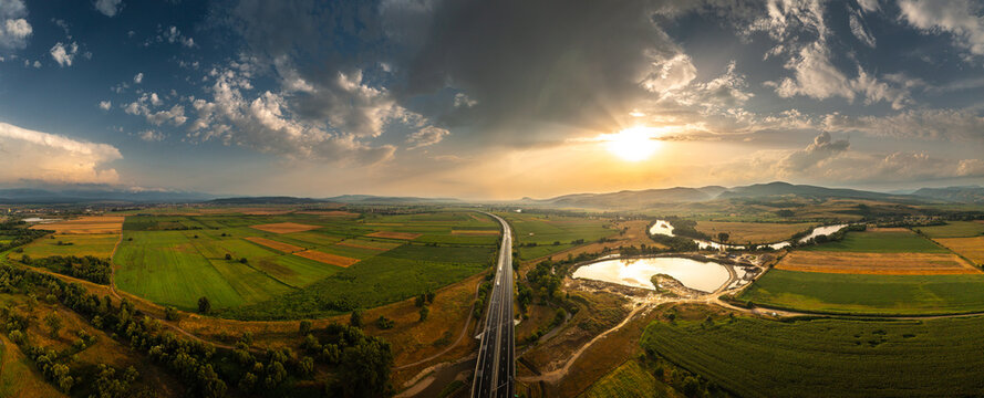 Aerial panoramic photo from above with A1 highway road between Sebes and Deva. Drone photo with the roads of Romania. Aerial view during sunset after a summer storm.