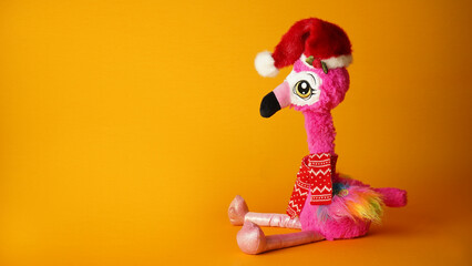 Tropical banner  flamingo in Sant Claus hat on a yellow background. 
