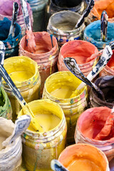 Large group of open cans of multi-colored paints