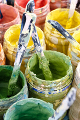 Large group of open cans of multi-colored paints