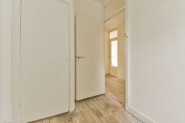an empty room with wooden floors and white doors that are open to reveal the light coming in through the window