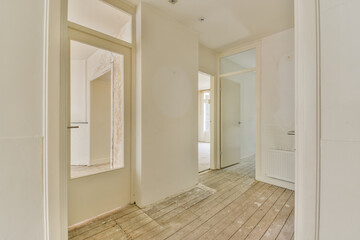 an empty room with wood flooring and white paint on the walls, there is a large mirror in the corner