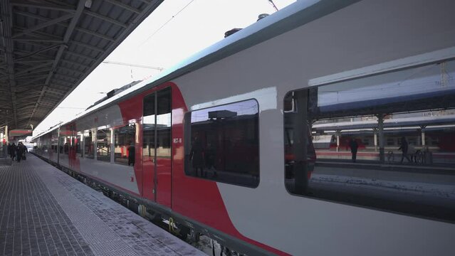 A modern high-speed train on the platform in winter. Railway platform with train