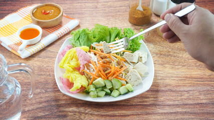 Raw vegetable salad or Asinan Betawi is a traditional food from Indonesia made of cabbage bean sprouts tofu cucumber carrot peanut sauce crackers