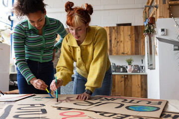 Young adults making demonstration banners for a climate change protest