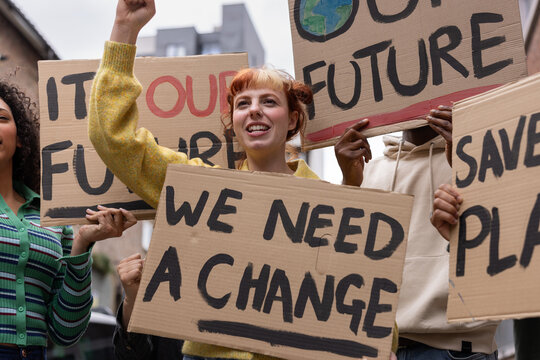 Young adult female protester raising her fist up