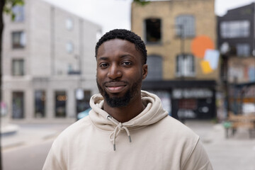 Portrait of young adult black male student on city street