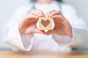 Doctor hand holding heart shape block in hospital. love, donor, world heart day, world health day, CSR donation and Insurance concepts