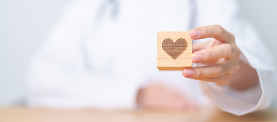Doctor hand holding heart shape block in hospital. love, donor, world heart day, world health day, CSR donation and Insurance concepts