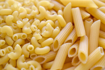 Uncooked Elbow pasta and Penne pasta background.  Italian food. 