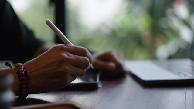 Bracelet wearing man hands draw on a tablet