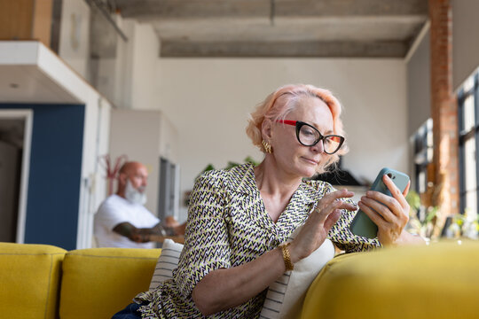 Cool senior woman at home using a smartphone