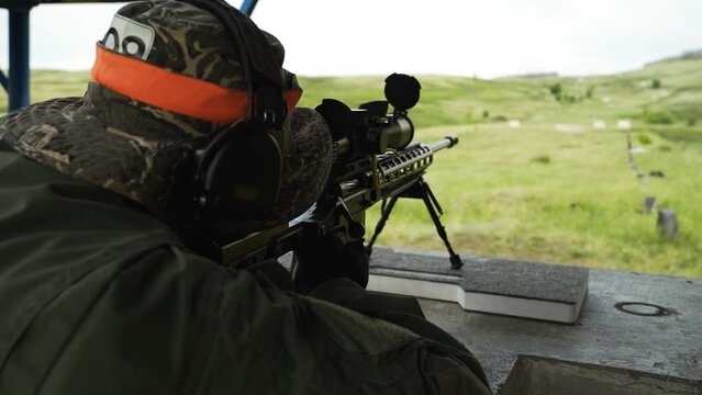 The sniper look through the optical sight of the rifle and fire a shot