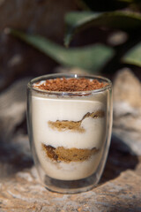 classic tiramisu dessert in a transparent glass.