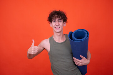 Funny guy goes in for sports in the gym. Orange background.