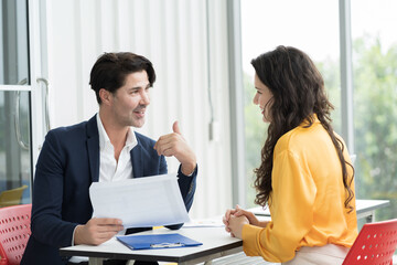 Business man and business woman discussing strategy business planning together on office desk in office. Two man and woman partnership meeting and working with document paper in office