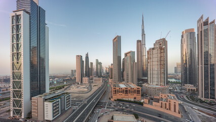 Naklejka na ściany i meble Aerial panoramic view of Dubai Downtown skyline with many towers day to night timelapse.