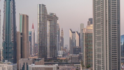 Many towers and skyscrapers with traffic on streets in Dubai Downtown and financial district day to night timelapse.