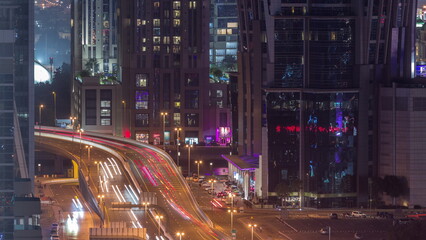 Fototapeta na wymiar Top aerial view of busy road intersection and traffic junctions in Dubai city night timelapse.
