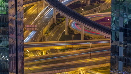 Aerial view from above to a busy road junction in Dubai night timelapse.
