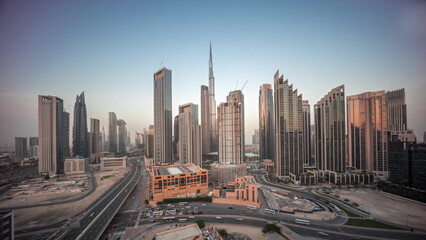 Fototapeta na wymiar Aerial view of Dubai Downtown skyline with many towers day to night timelapse.