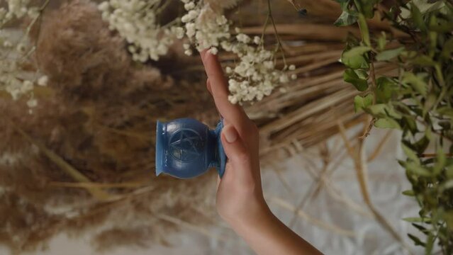 occult objects. an occult candle in a woman's hands. mysticism, occultism, magic. vertical shot of a candle in a woman's hands