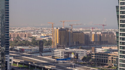 Construction site around Dubai water canal with many cranes aerial timelapse.