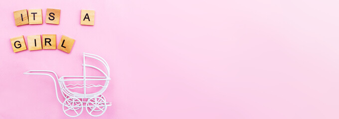 Its a girl. Little vintage white baby carriage stroller or pram on a pink background.