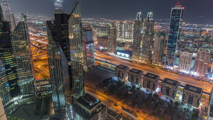 Naklejka na ściany i meble High-rise buildings on Sheikh Zayed Road in Dubai aerial night timelapse, UAE.
