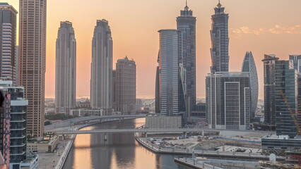 Fototapeta na wymiar Cityscape with skyscrapers of Dubai Business Bay and water canal aerial timelapse during sunset.