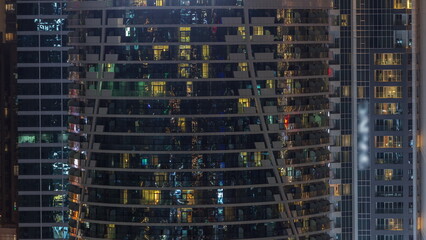 Fototapeta na wymiar Residential buildings windows illuminated at night timelapse