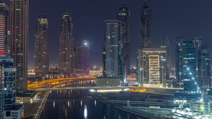 Obraz na płótnie Canvas Cityscape with skyscrapers of Dubai Business Bay and water canal aerial night to day timelapse.