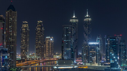 Fototapeta na wymiar Cityscape with skyscrapers of Dubai Business Bay and water canal aerial all night timelapse.