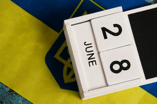 Wooden calendar and flag of Ukraine close-up. Constitution Day of Ukraine.