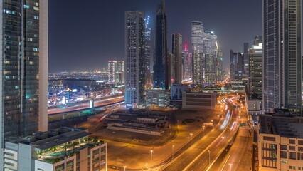 Fototapeta na wymiar Many towers and skyscrapers with traffic on streets in Dubai Downtown and financial district night timelapse.
