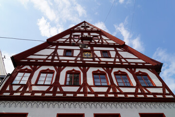 a beautiful ancient Bavarian town of Noerdlingen with its half-timbered houses with red geraniums on a summer day (Bavaria, Germany)	
