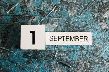 Wooden calendar on a dark background. The date is September 1, the Day of Knowledge.