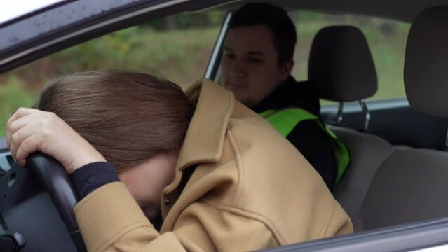 Side view stressed young woman listening to ,man talking and leaning on steering wheel. Worried Caucasian female student with male teacher in car outdoors